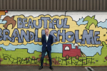Cllr Rydeheard at the 'Beautiful Brandlesholme' climbing wall in the playground at Woodbank Primary School